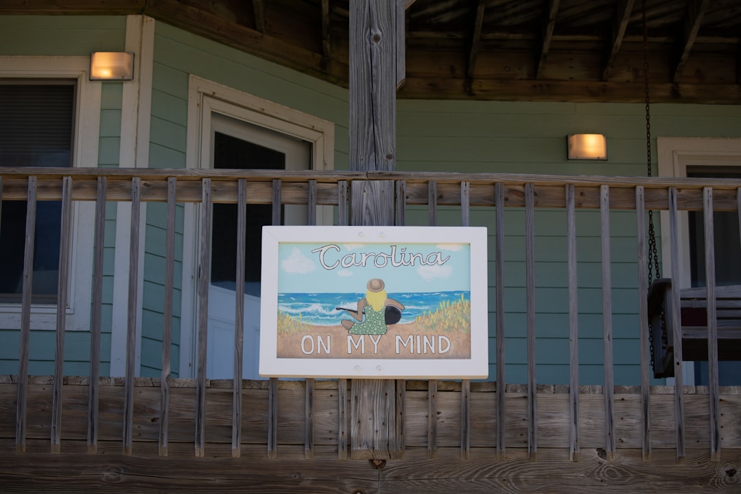 white and blue signage on white steel fence