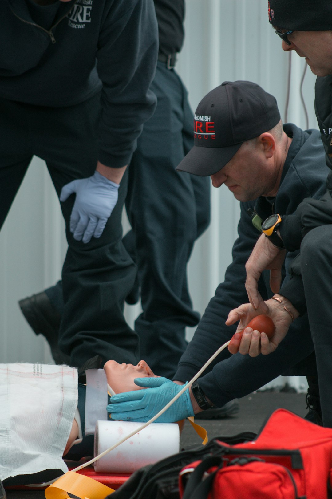 a group of people standing around a person with a glove on