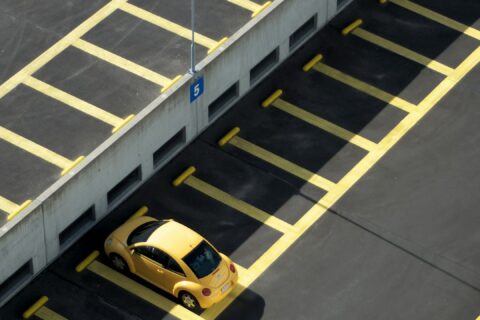 yellow coupe on parking lot at daytime