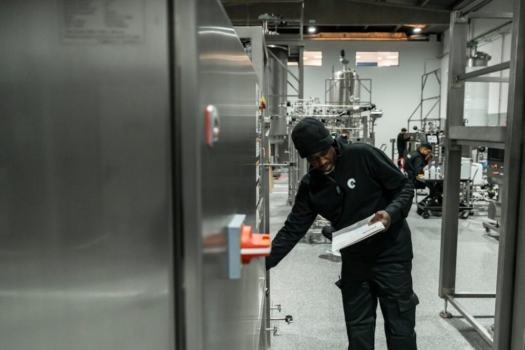 A man inspects equipment in a modern factory.