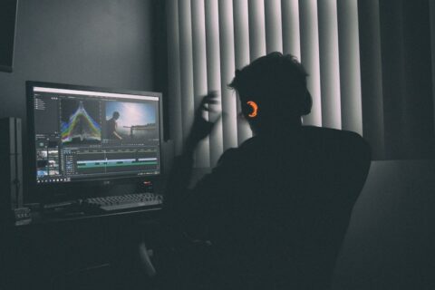 shallow focus photography of man listing to music in front of the computer