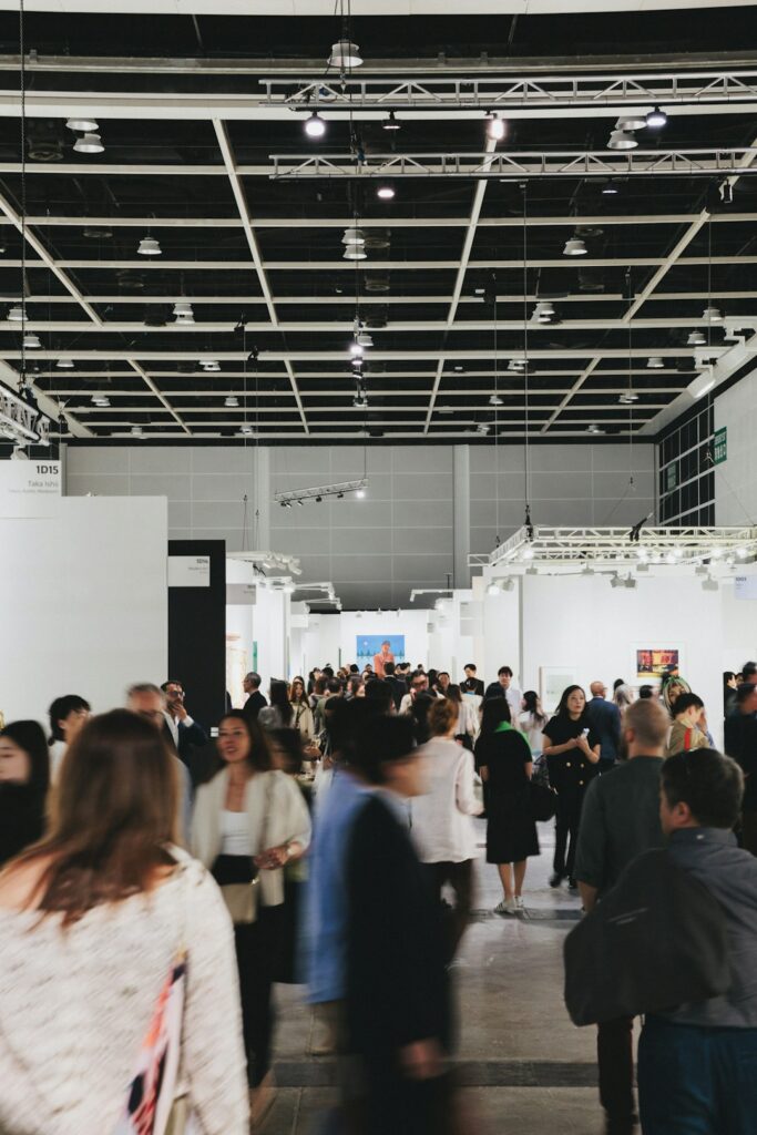 People browse art in a busy, modern gallery.