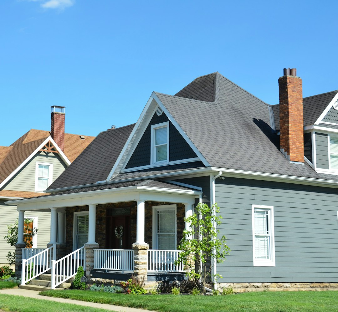 A blue house with a white porch and red chimney