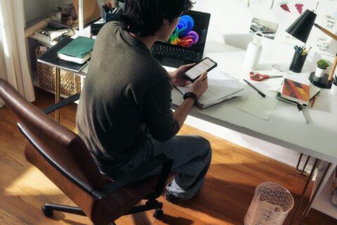 Man working at desk with laptop and phone