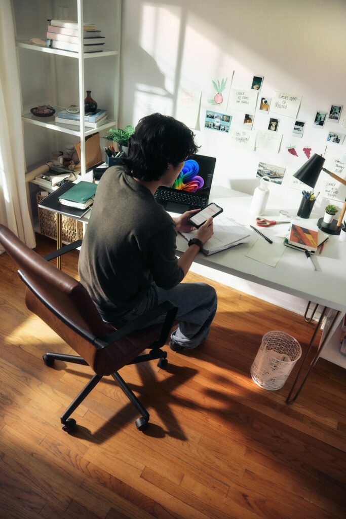 Man working at desk with laptop and phone